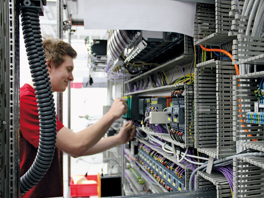 F.EE employee wiring a switch cabinet